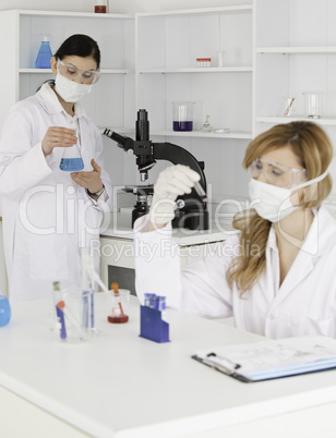 Dark-haired and blond-haired scientists conducting an experiment