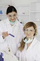 Female scientists with safety glasses looking at the camera