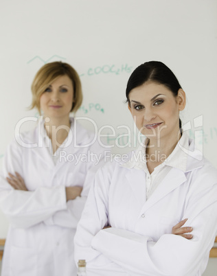 Two scientists posing in front of a white board