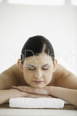 Dark-haired woman getting a spa treatment while closing her eyes