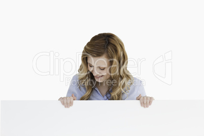 Blond-haired woman standing behind an empty white board