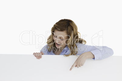 Attractive blond-haired woman standing behind a white board