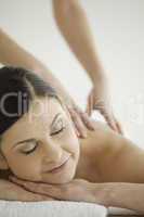 Beautiful dark-haired woman enjoying a massage