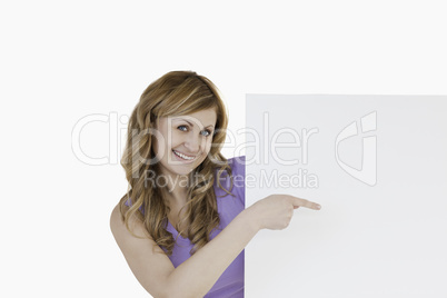 Cute blond-haired woman holding a white board