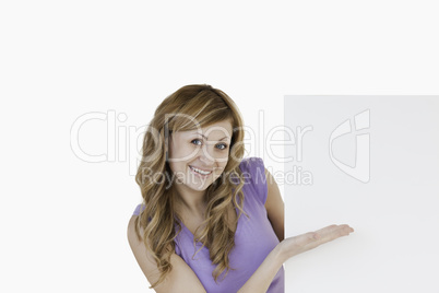 Happy blond-haired woman holding a white board