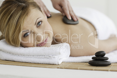 Therapist making a massage to a pretty blond-haired woman