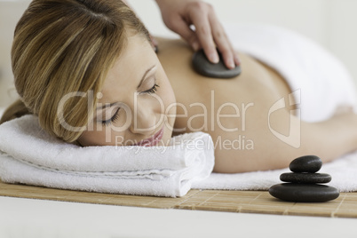 Therapist making a massage to a lovely blond-haired woman