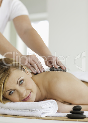 Therapist making a massage to a young blond-haired woman