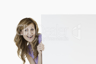 Smiling blond-haired woman holding a white board