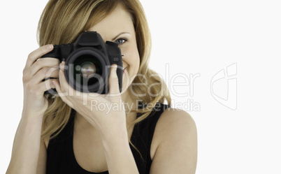 Cute blond-haired woman taking a photo with a camera