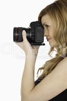 Lovely blond-haired woman taking a photo with a camera