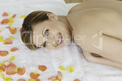 Cute blond-haired woman looking at the camera while lying down