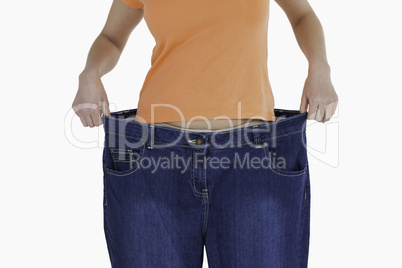 Slim woman showing how much weight she lost