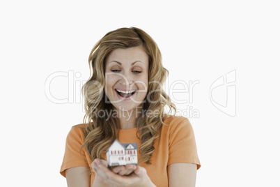 Happy woman holding an house model