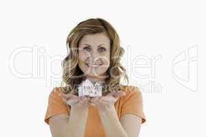 Smiling woman holding an house model