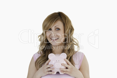 Attractive woman posing while holding her piggybank