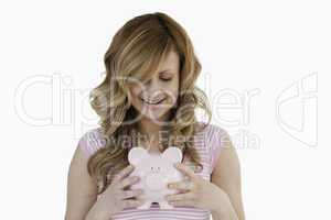 Lovely woman posing while holding her piggybank