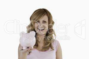 Attractive blond-haired woman posing while holding her piggybank
