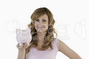 Cute blond-haired woman posing while holding her piggybank