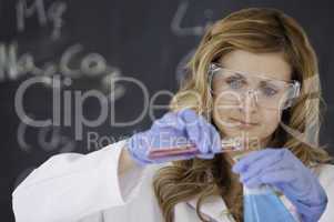 Young female scientist carrying out an experiment