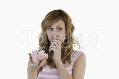 Blond-haired woman perplexed concerning her broken piggybank