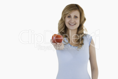 Cute woman showing a red apple to the camera