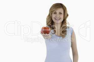 Cute woman showing a red apple to the camera