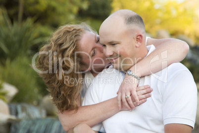 Attractive Couple Kiss on the Cheek in the Park.