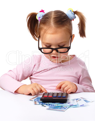 Little girl plays with money