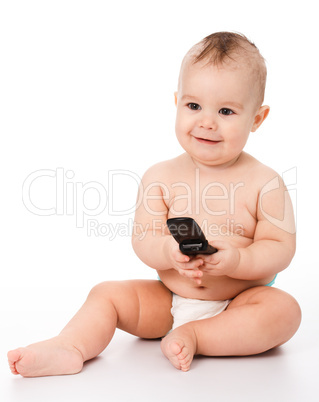 Happy little baby plays with mobile phone