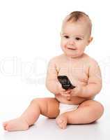 Happy little baby plays with mobile phone