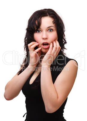 Young woman holding her face in astonishment