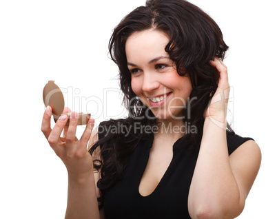 Girl is looking at herself in mirror