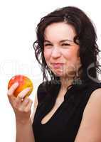 Woman is making sour face after biting an apple