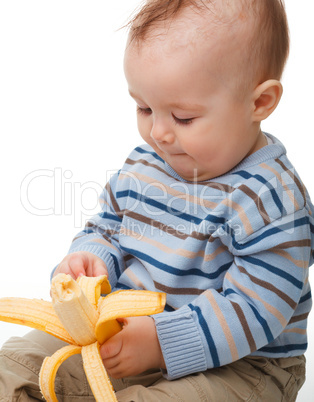 Little boy eats banana