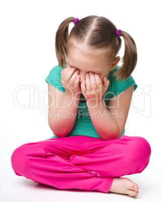 Little girl is sitting on floor and crying