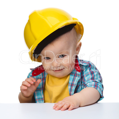 Cute little boy wearing oversized hard hat