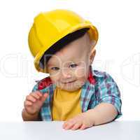 Cute little boy wearing oversized hard hat