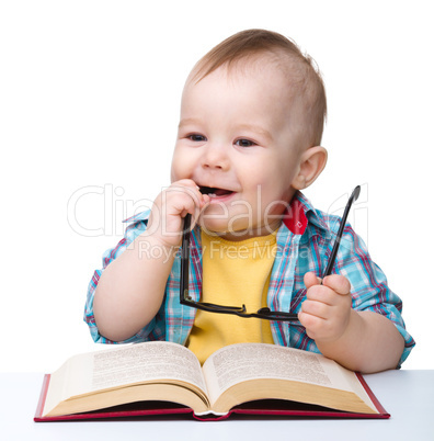 Little child play with book and glasses