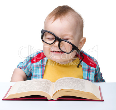 Little child play with book and glasses