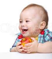 Little child is eating red apple and smile