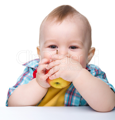 Little child is biting red apple and smile