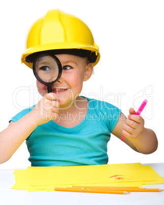 Cute little girl is looking through magnifier