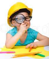 Cute little girl is looking through magnifier