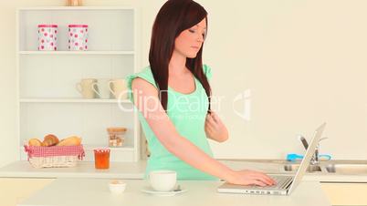 junge Frau mit Laptop in der Küche
