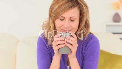 junge blonde Frau trinkt tee