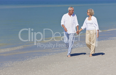 Happy Senior Couple Walking Holding Hands on Beach