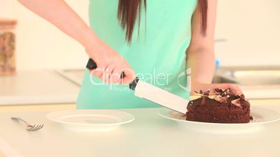 Frau schneidet Stück Kuchen ab