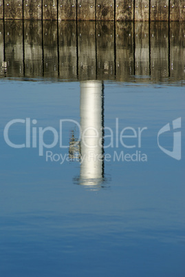 Spiegelung von einem Poller im Wasser