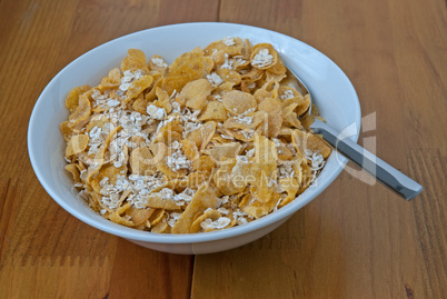 White bowl with a spoon, corn and oats flakes